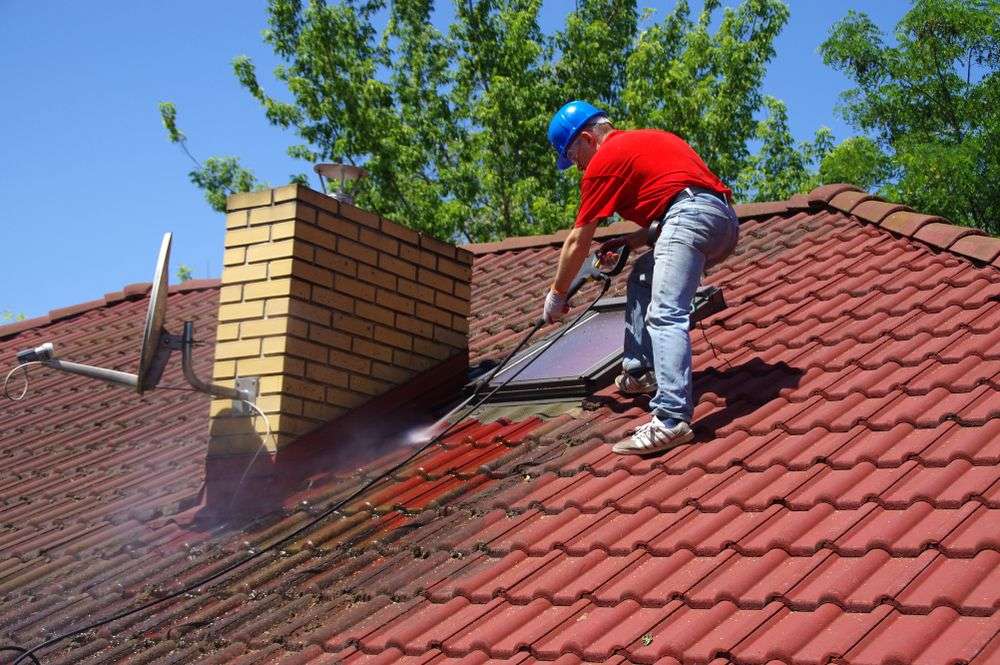 Schoonspuiten van de dakpannen in Goes